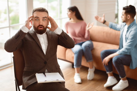 Couple arguing at therapy session, man therapist grabbing headの写真素材