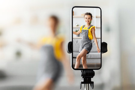 Teen girl dancing at camera filming video on cell phone