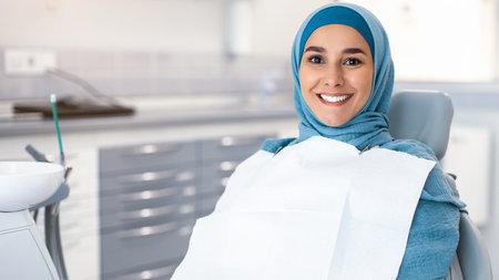Portrait Of Happy Muslim Woman Patient Sitting In Chair In Dental Clinicの写真素材
