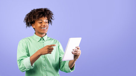 Happy black teen guy browsing web on tablet pc over blue background and smiling