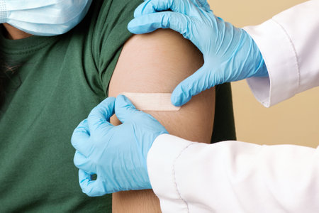 Nurse in workwear and gloves making vaccination
