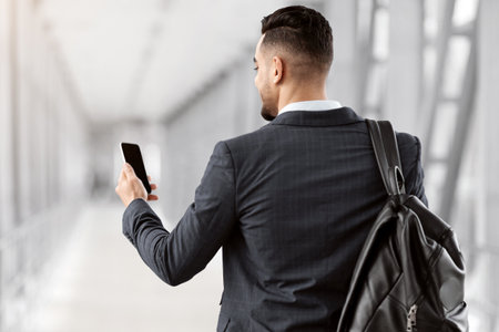 Arab Man With Backpack Using Blank Smartphone In Airportの写真素材