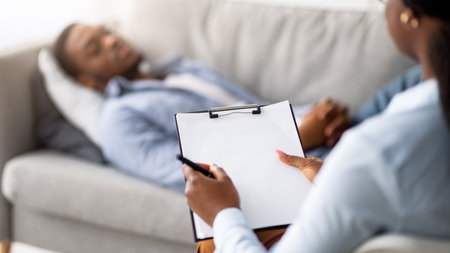 Stress and psychological trauma. Psychologist working with depressed black man at office, mockup on clipboardの写真素材