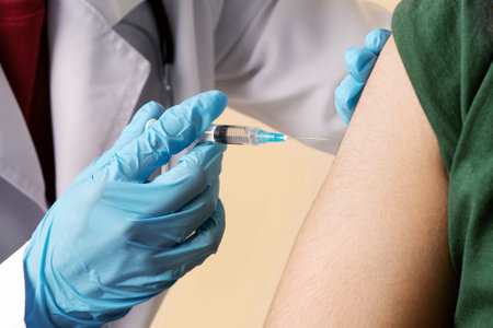 Doctor making intramuscular injection for man at clinic