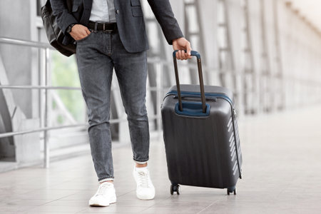 Unrecognizable Man In Casual Clothes Walking With Luggage At Airport Terminalの写真素材