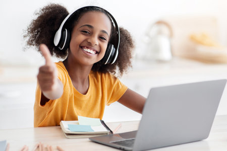 Positive african american teen girl enjoying home schooling