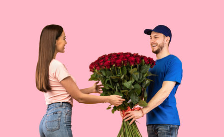 Flowers Delivery Courier Giving Woman Bouquet Of Roses, Yellow Backgroundの写真素材
