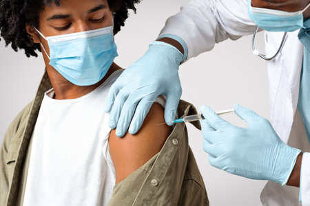 Vaccination Concept. Doctor Giving Shot Or Vaccine Injection To Black Male Patient