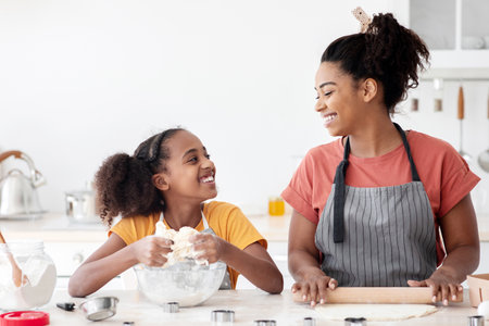 Joyful african american mother and daughter baking together