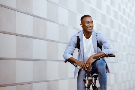 Happy man listening to music while riding bike, space for textの写真素材