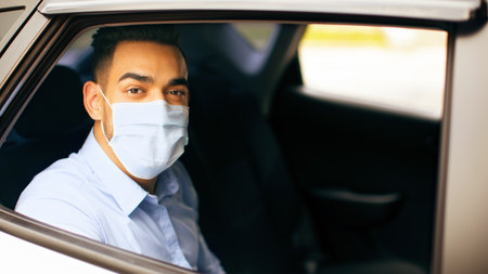 Middle-eastern man in protective face mask sitting at taxiの写真素材