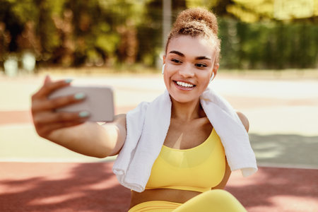 Black lady making selfie photo on smartphone during workout break