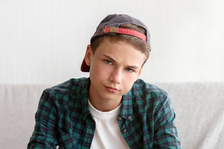 Bored teen boy sitting on couch