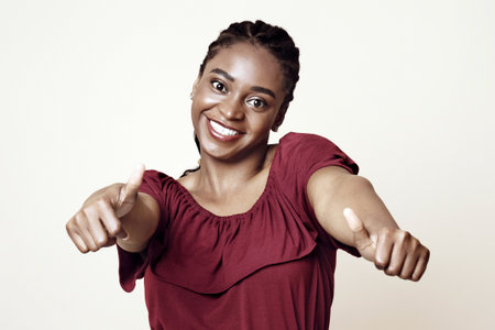 Positive african american young woman showing thumb ups