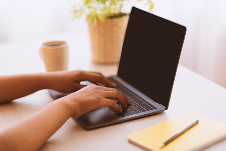 African American Woman Using Laptop With Black Empty Mockup Screenの写真素材