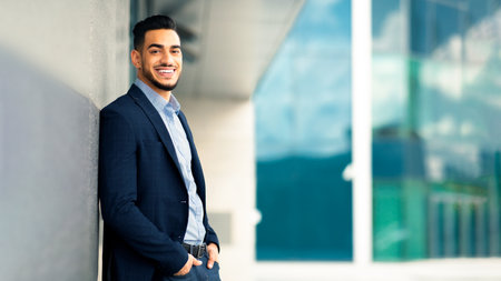 Successful arabic entrepreneur standing outside office building, side viewの写真素材