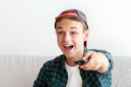 Carefree boy watching football chanels on TVの写真素材