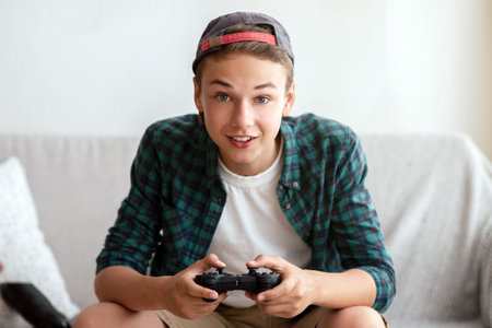 Excited teenager playing video games at homeの写真素材