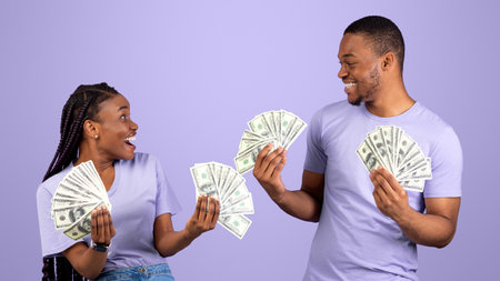 Excited African American couple holding a lot of moneyの写真素材