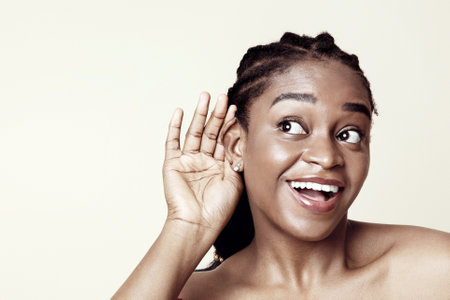 Curious african american young woman listening to somethingの写真素材