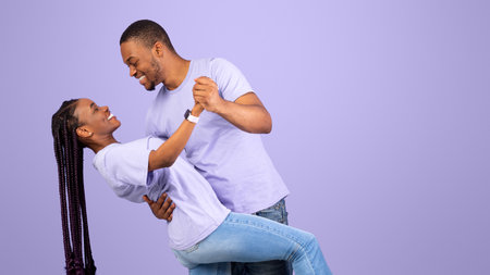 Portrait of romantic black couple dancing at studio