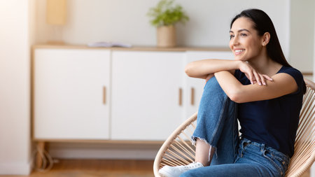 Happy Woman Relaxing Sitting In Cozy Modern Chair At Homeの写真素材