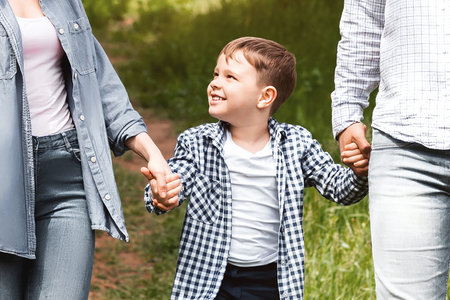 Family bonding times. Young parents and their son on a walk together in countrysideの写真素材