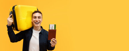 Happy young man travelling abroad, holding suitcase and passportの写真素材