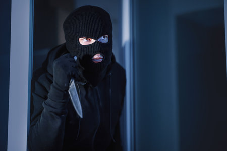 Criminal breaking in an apartment or office holding knifeの写真素材