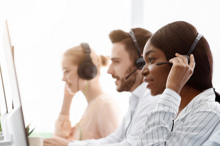 Telemarketing or customer service team providing assistance to clients at call centre officeの写真素材