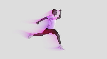 Athletic man in mid-air running pose on greyの写真素材