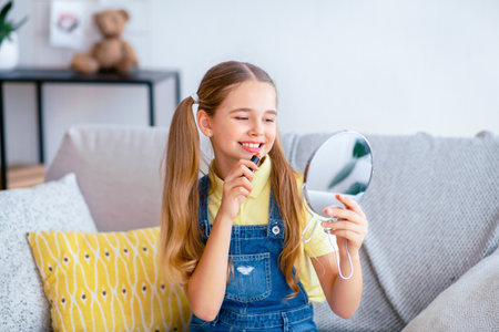 Young Girl Holding Lipstick, Looking At Mirrorの写真素材