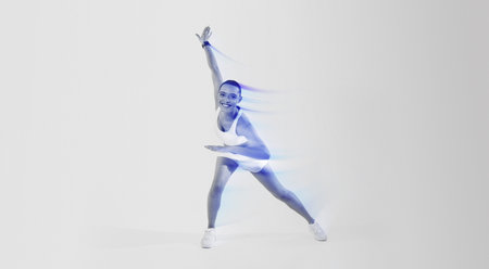 A joyful woman with a shaved head in a dynamic yoga pose, wearing a white sports outfit and sneakersの写真素材