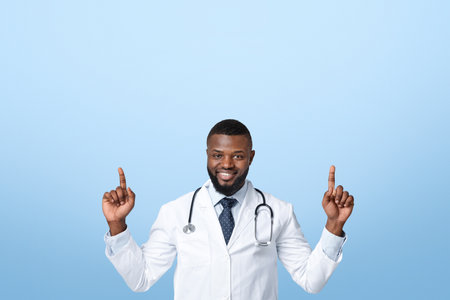 Happy african doctor pointing up at free spaceの写真素材