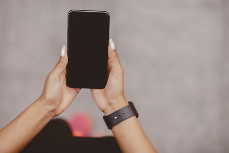 Smartphone for fitness blog. Girl with fitness tracker holds phone with blank screen
