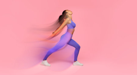 African American woman in fitwear performing backbend in lunge position, studioの写真素材