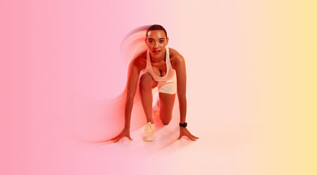 Positive young latin woman athlete in sportswear stands at start, ready to runの写真素材