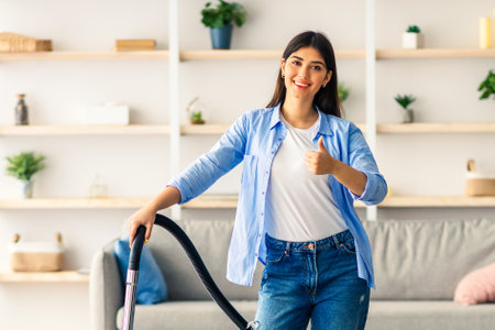 Young woman enjoys housekeeping while cleaning her modern homeの写真素材