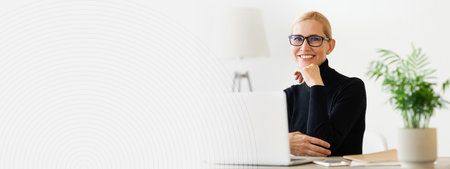 Professional Woman Working at Desk With Laptop and Indoor Plant During Daytimeの写真素材