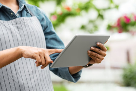 Easy work with modern technology in greenhouses. African american woman working with digital tablet