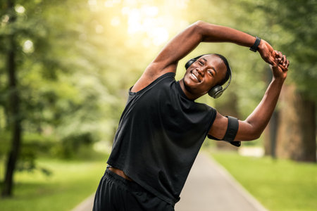 Joyful african guy having morning training at parkの写真素材