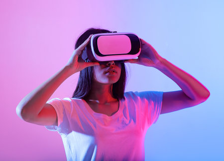 Engaging in virtual reality with vibrant lighting at homeの写真素材