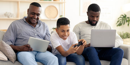 Family enjoying quality time playing video games and using devices indoorsの写真素材