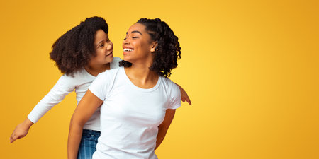 Family Fun. Joyful African Mom Giving Her Daughter Piggyback Rideの写真素材