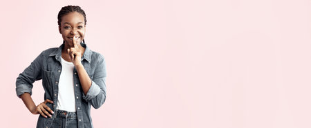 Young woman smiling playfully against a pink backgroundの写真素材