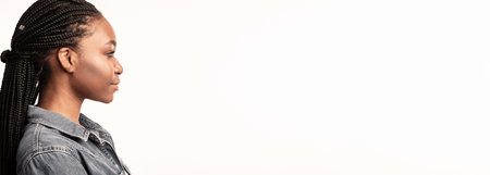 Profile view of a young woman with braided hair against a neutral backgroundの写真素材