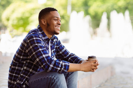 Portrait of african american guy sitting with coffeeの写真素材