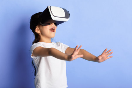 Little asian girl wearing virtual reality goggles at the studio
