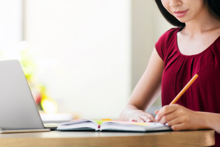 Beautiful Asian Student Girl Studying With Laptop In Cafe And Taking Notesの写真素材