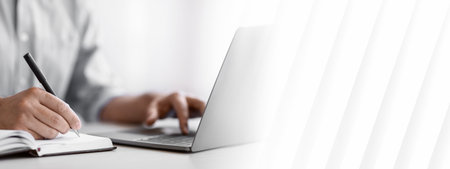 Unrecognizable Man Writing In Notepad And Using Laptop In Office, Closeupの写真素材